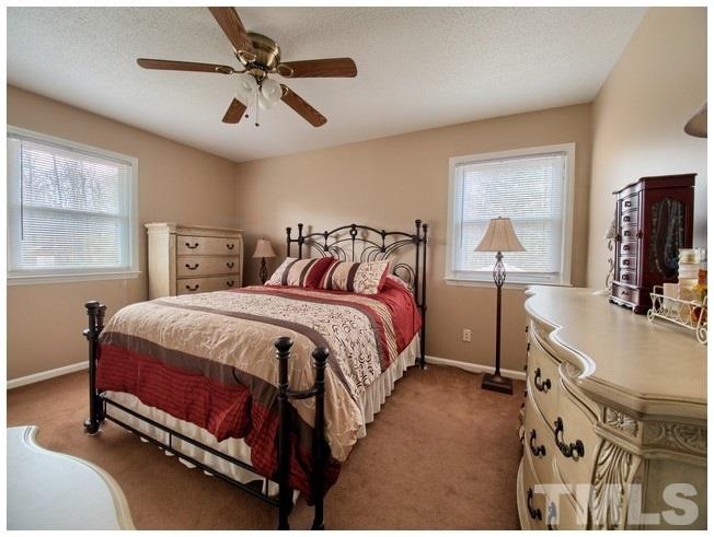 908 Orange Factory Road Bahama, NC 27503 - Photo 18 of 23 a spacious bedroom with a bed a chandelier and a mirror