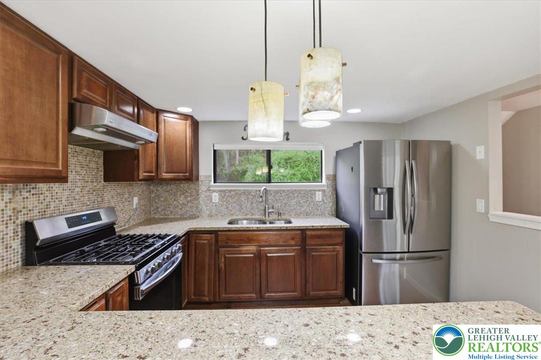 612 Mountain View Way Bushkill, PA 18324 - Photo 7 of 31 a kitchen with stainless steel appliances granite countertop a sink stove and refrigerator