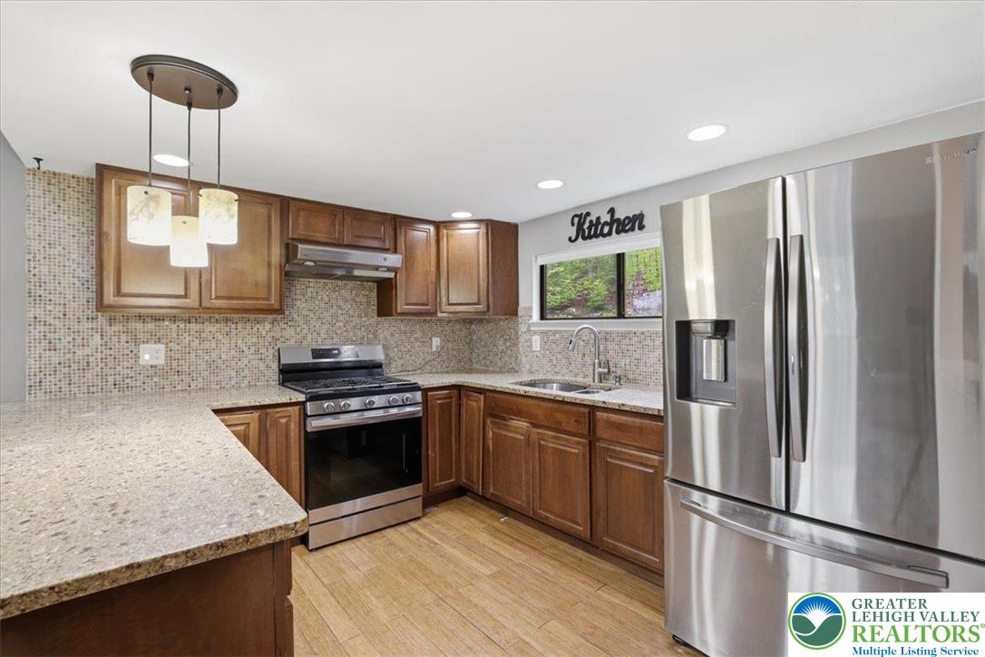 612 Mountain View Way Bushkill, PA 18324 - Photo 8 of 31 a kitchen with stainless steel appliances granite countertop a refrigerator a sink dishwasher a stove and white cabinets with wooden floor