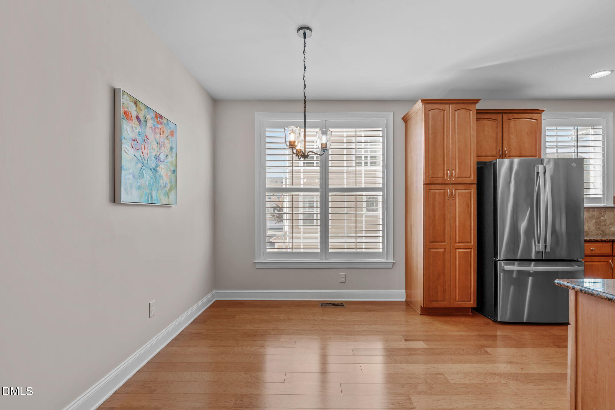 10410 Sablewood Drive, Unit 109 Raleigh, NC 27617 - Photo 11 of 42 a view of a kitchen with a refrigerator cabinets and a wooden floor