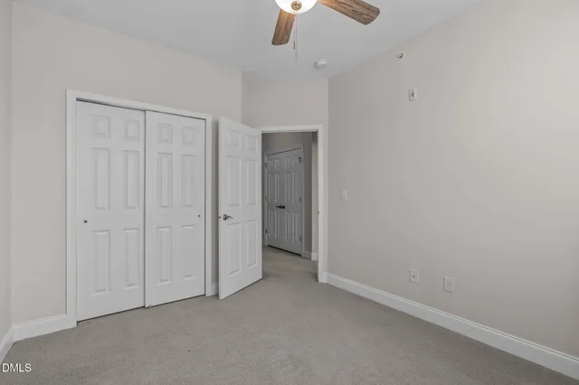 a view of an empty room with a ceiling fan