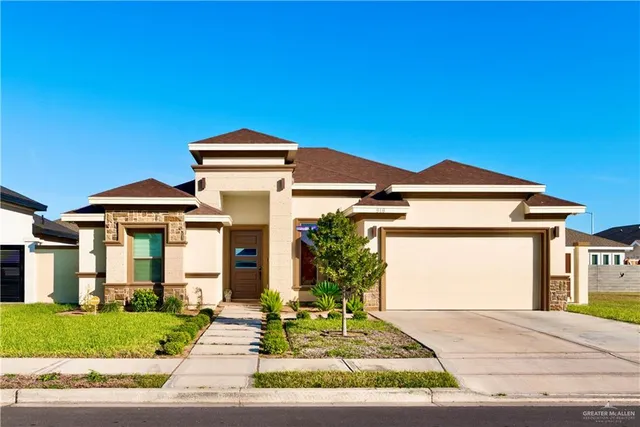 a front view of a house with a yard and garage