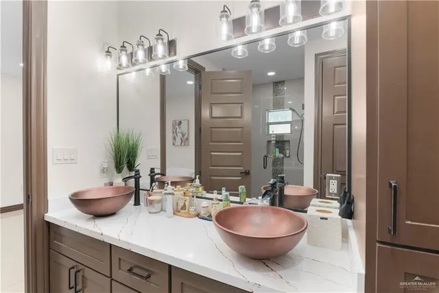 a bathroom with a granite countertop sink a toilet a mirror and shower