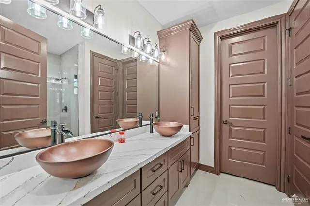 a bathroom with a granite countertop sink a toilet and shower