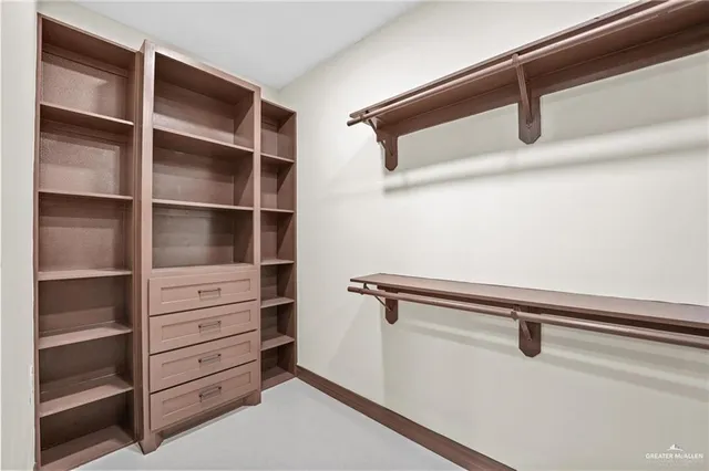 a view of walk in closet with empty racks