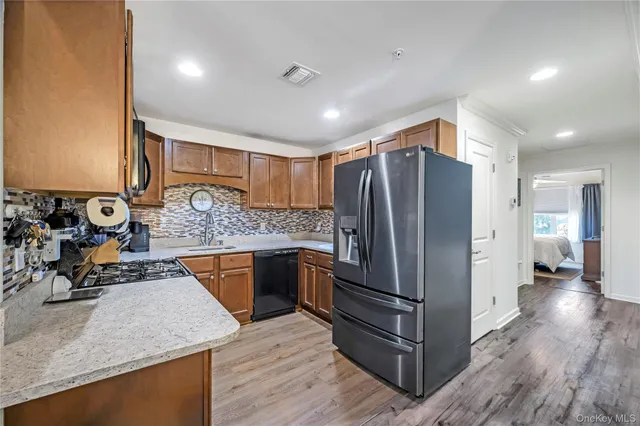 a kitchen with stainless steel appliances granite countertop a refrigerator and a sink