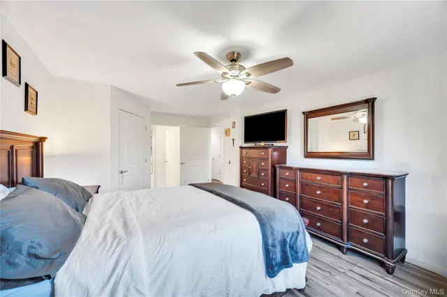 a bedroom with a bed a chandelier and a television