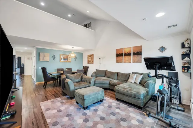 a living room with furniture a flat screen tv and a table