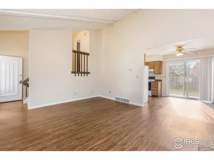 a view of an empty room with window and wooden floor