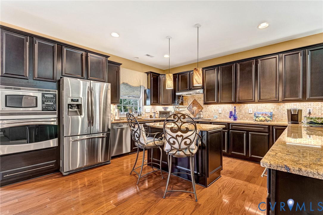 5221 Preston Square Loop Glen Allen, VA 23059 - Photo 2 of 30 a kitchen with stainless steel appliances granite countertop a table chairs sink refrigerator and cabinets