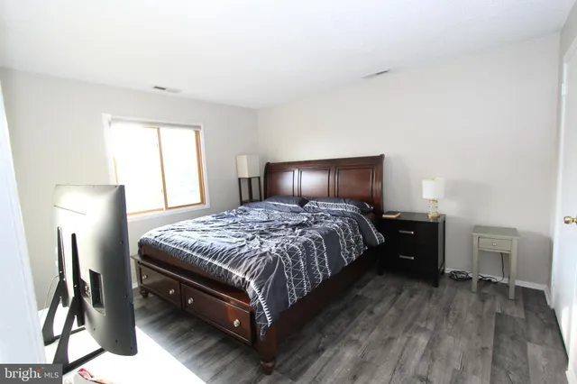 a bedroom with a bed lamp and a dresser