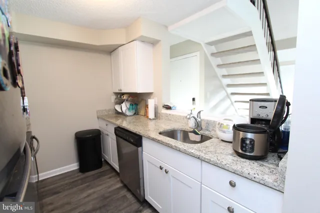 a kitchen with sink a stove and cabinets