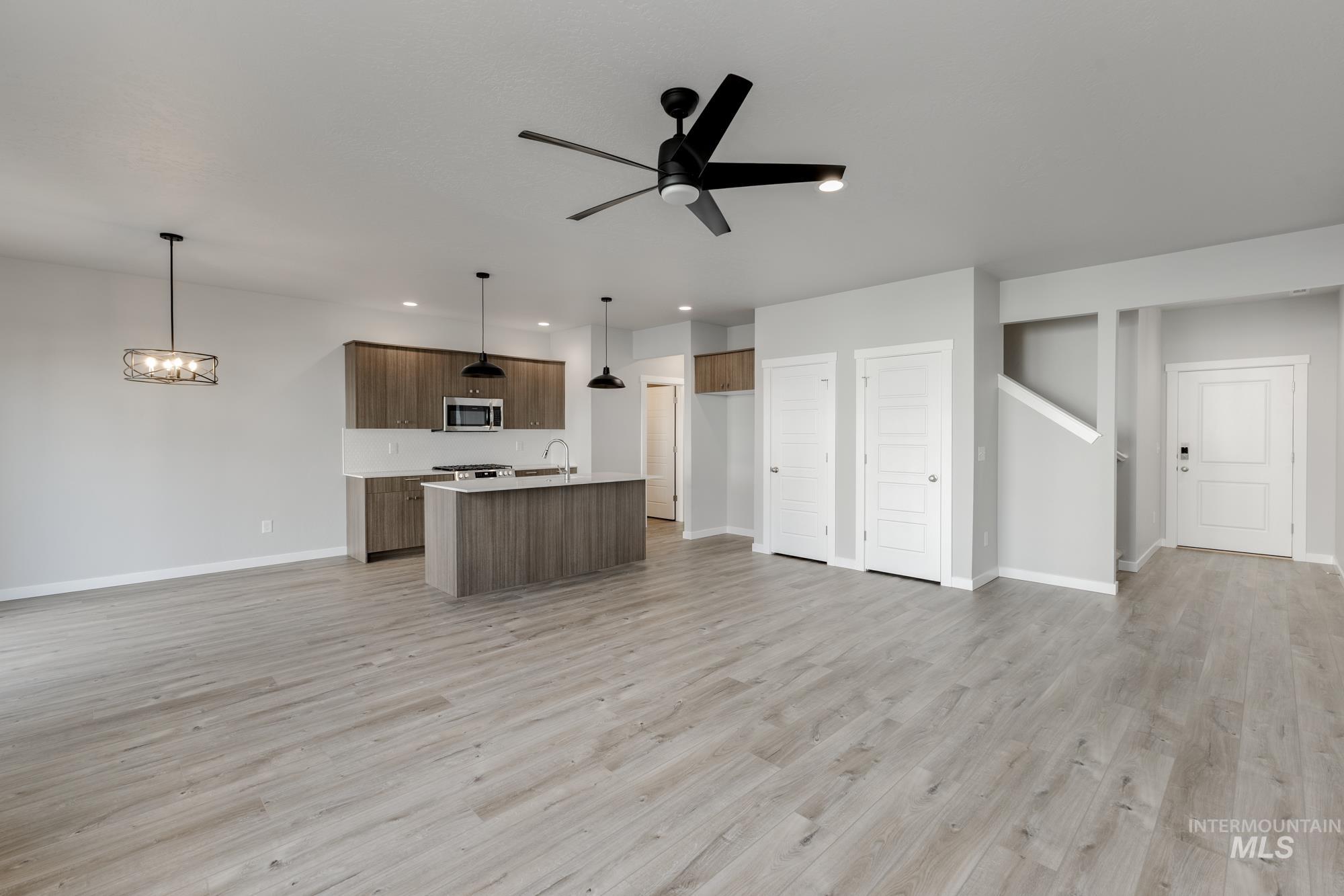 4166 East Kalinga Street Meridian, ID 83642 - Photo 22 of 22 Kitchen featuring open floor plan, light countertops, hanging light fixtures, a kitchen island with sink, and light wood-style floors