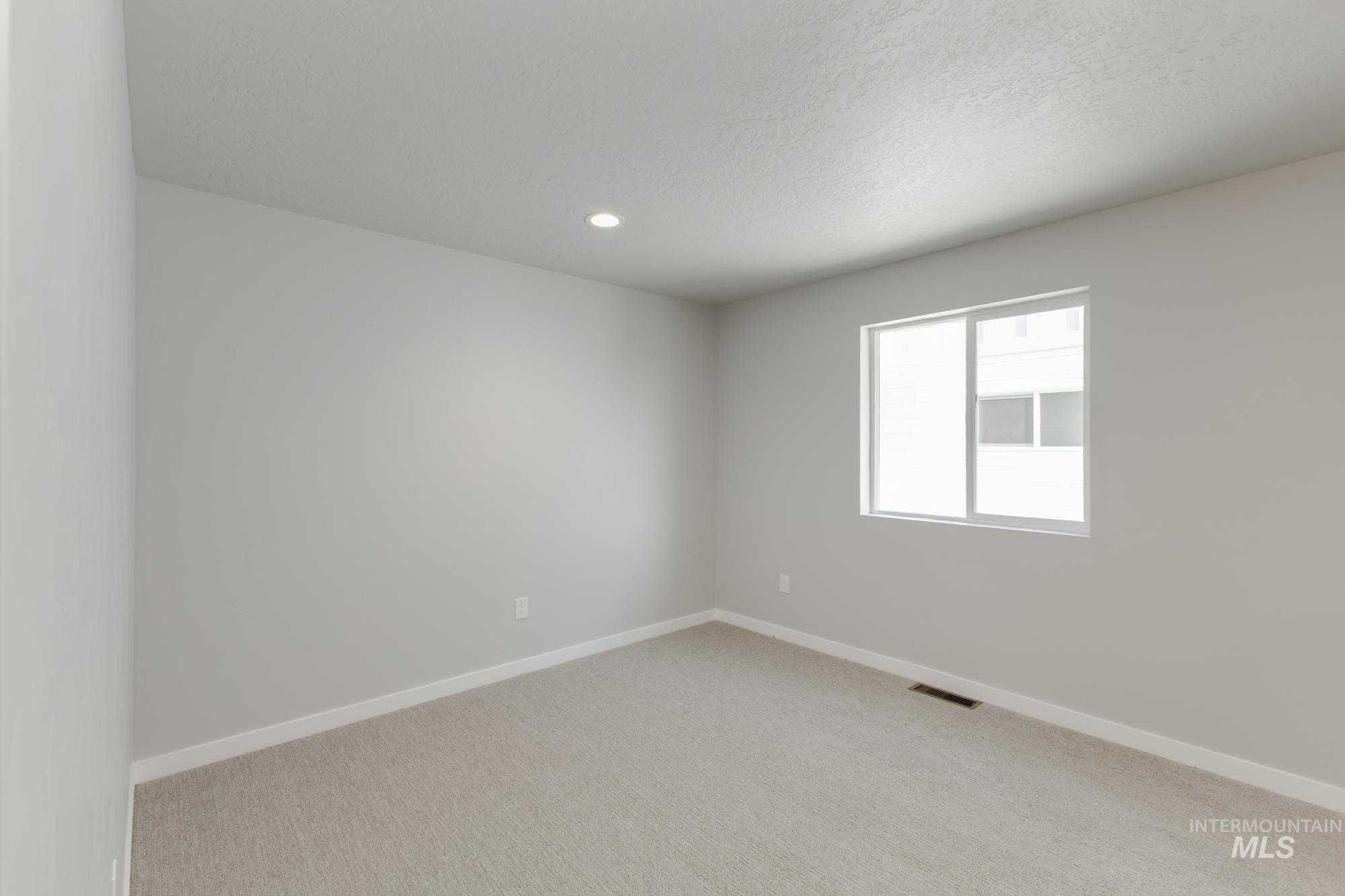 4166 East Kalinga Street Meridian, ID 83642 - Photo 11 of 22 Unfurnished room with light colored carpet, recessed lighting, and a textured ceiling