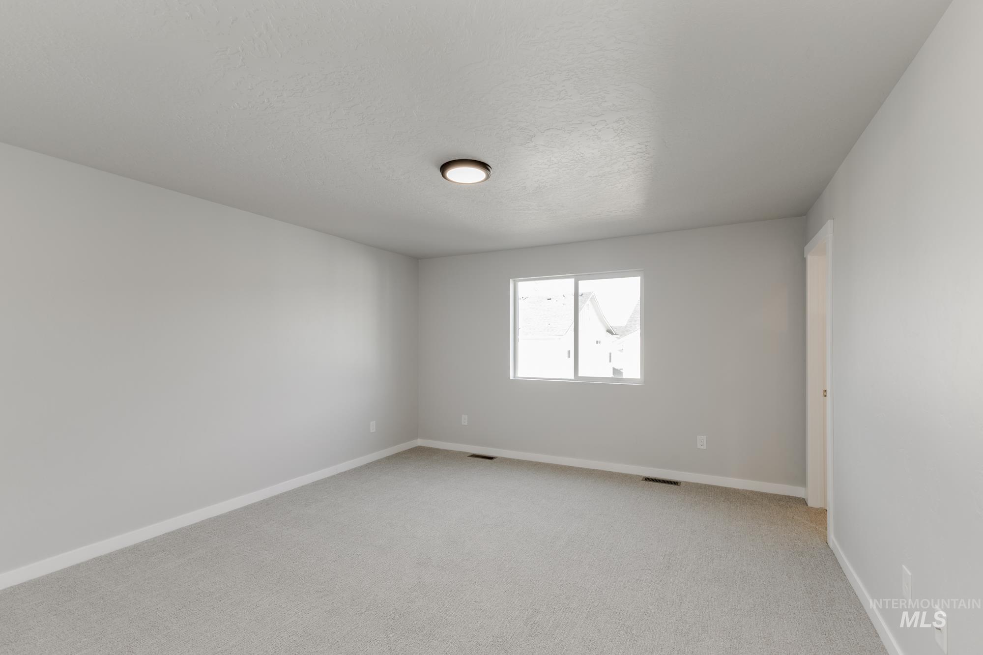 4166 East Kalinga Street Meridian, ID 83642 - Photo 17 of 22 Empty room with a textured ceiling and light carpet