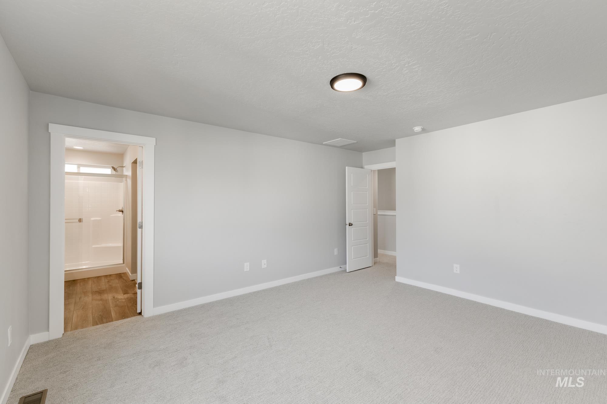 4166 East Kalinga Street Meridian, ID 83642 - Photo 18 of 22 Unfurnished bedroom featuring light carpet, a textured ceiling, and ensuite bath