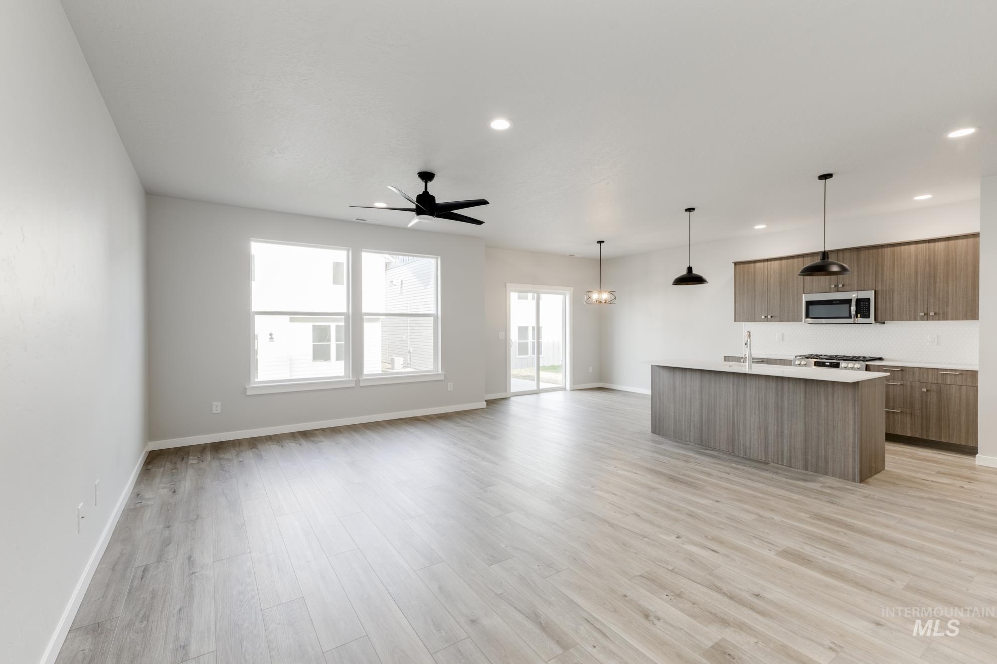 4166 East Kalinga Street Meridian, ID 83642 - Photo 21 of 22 Kitchen with open floor plan, a center island with sink, pendant lighting, light wood-style flooring, and ceiling fan