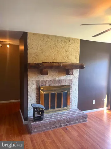 a view of an empty room with a fireplace and a wooden floor