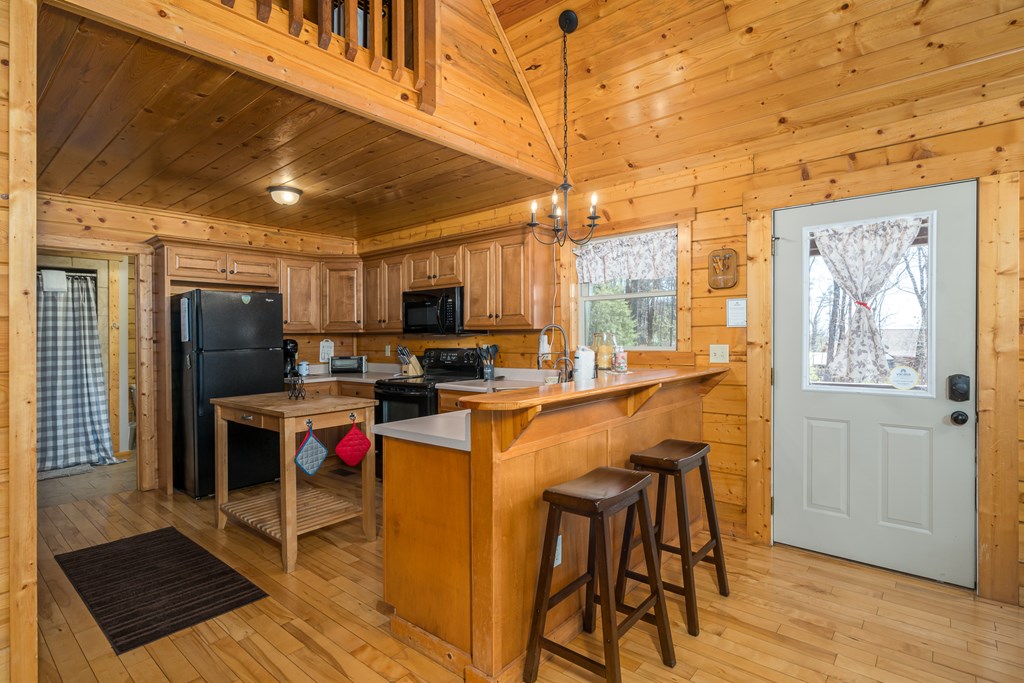 1529 Faith Court Ranger, GA 30734 - Photo 22 of 50 a open kitchen with stainless steel appliances kitchen island granite countertop a refrigerator a stove a sink a dining table and chairs with wooden floor