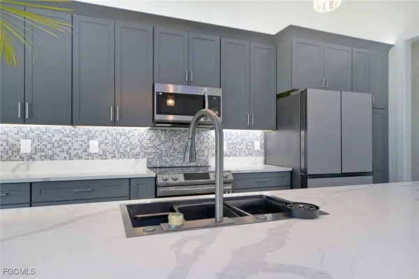 a kitchen with a stove a sink and a microwave