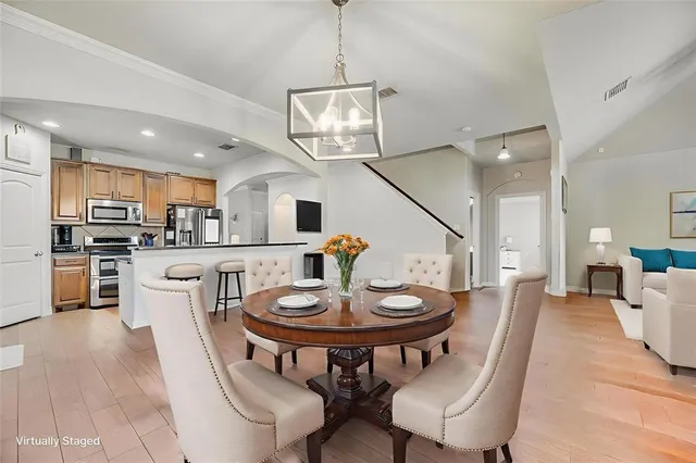 a kitchen with stainless steel appliances a dining table chairs stove and microwave