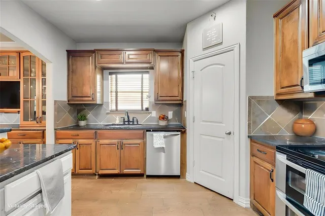 a kitchen with stainless steel appliances granite countertop a stove a sink and a refrigerator