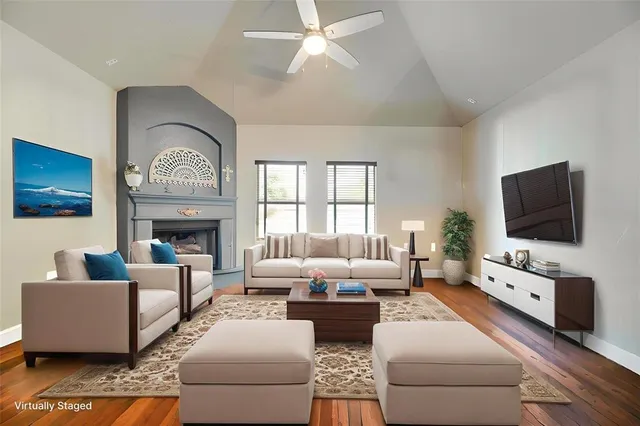a living room with furniture a flat screen tv and a fireplace