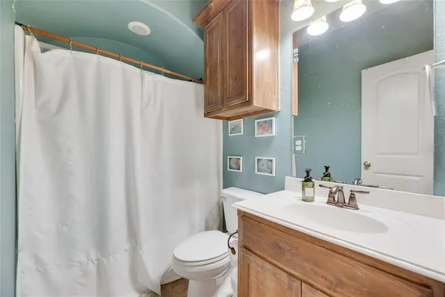 a bathroom with a sink a toilet and a mirror