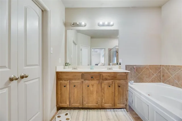 a spacious bathroom with a double vanity sink a mirror and a bathtub