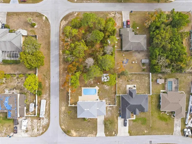 a view of swimming pool with seating area and trees in the background