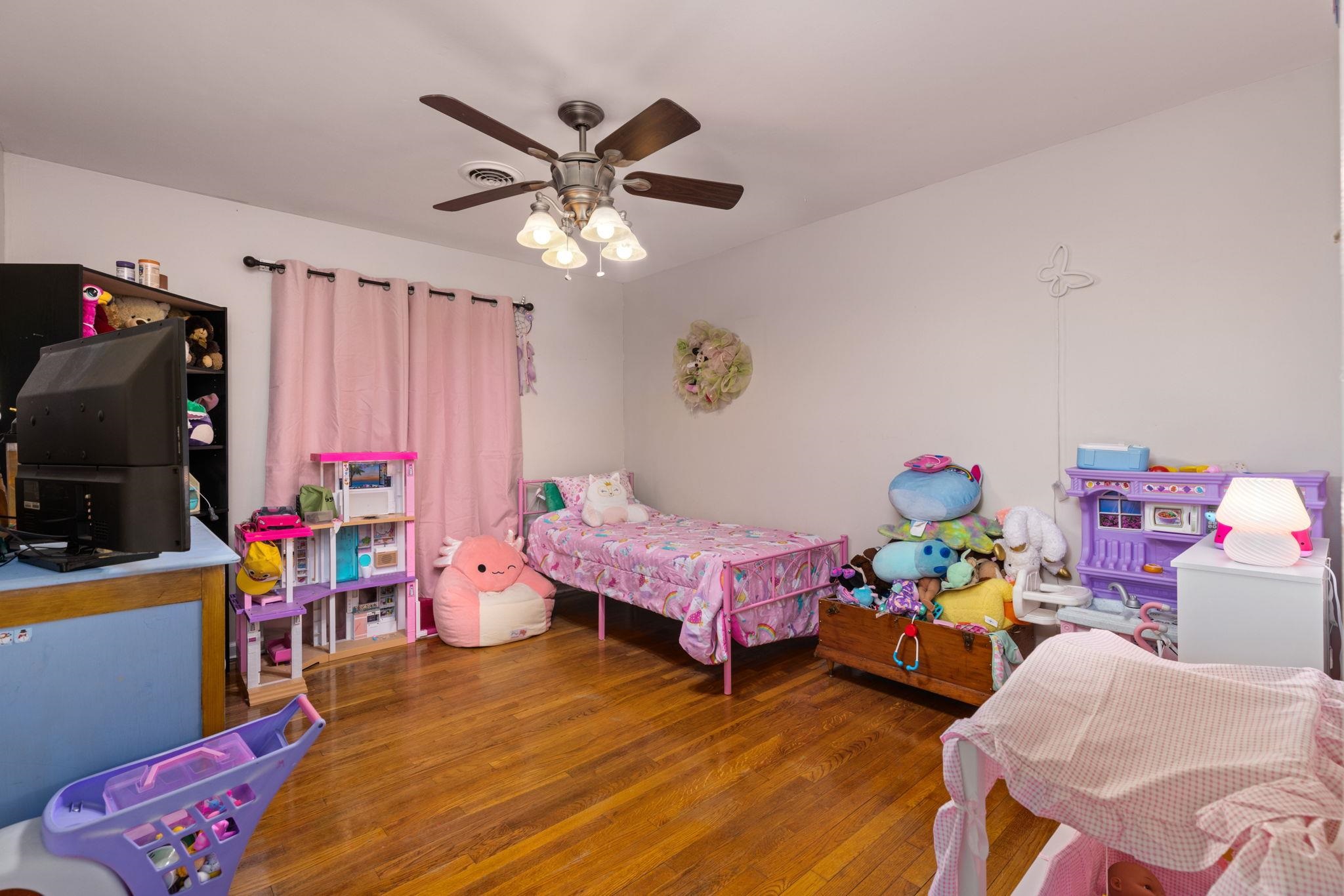 102 West 5th Street Iuka, MS 38852 - Photo 15 of 33 Spacious room featuring wood-finish flooring, a ceiling fan with integrated lighting, and white walls