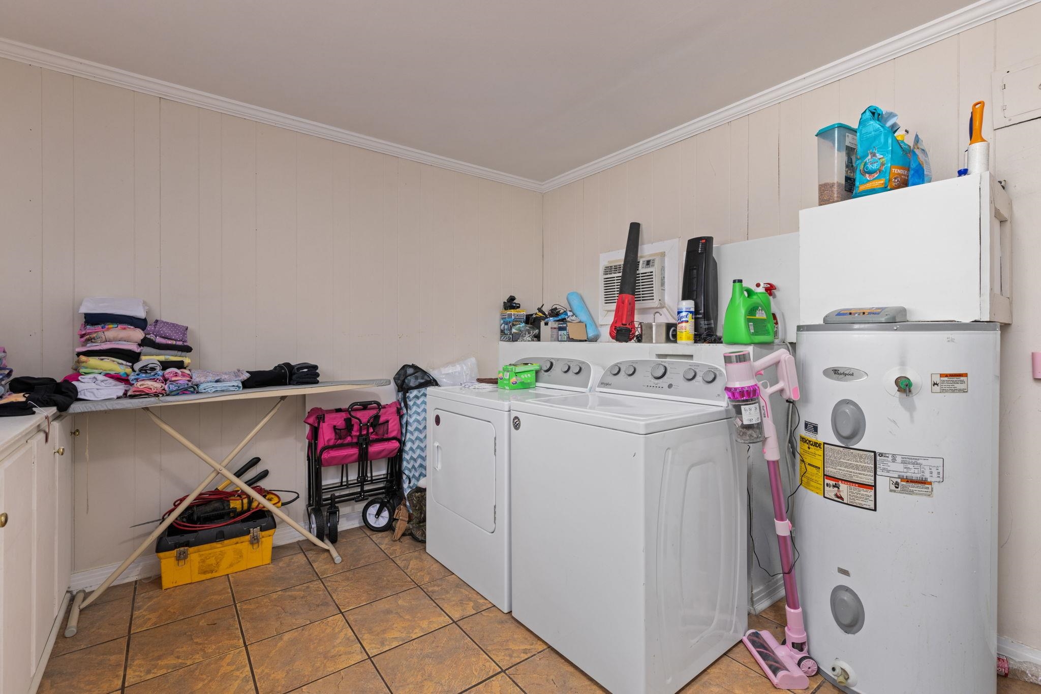 102 West 5th Street Iuka, MS 38852 - Photo 10 of 33 Utility room featuring a washer, dryer, built-in cabinetry, water heater, and tile flooring