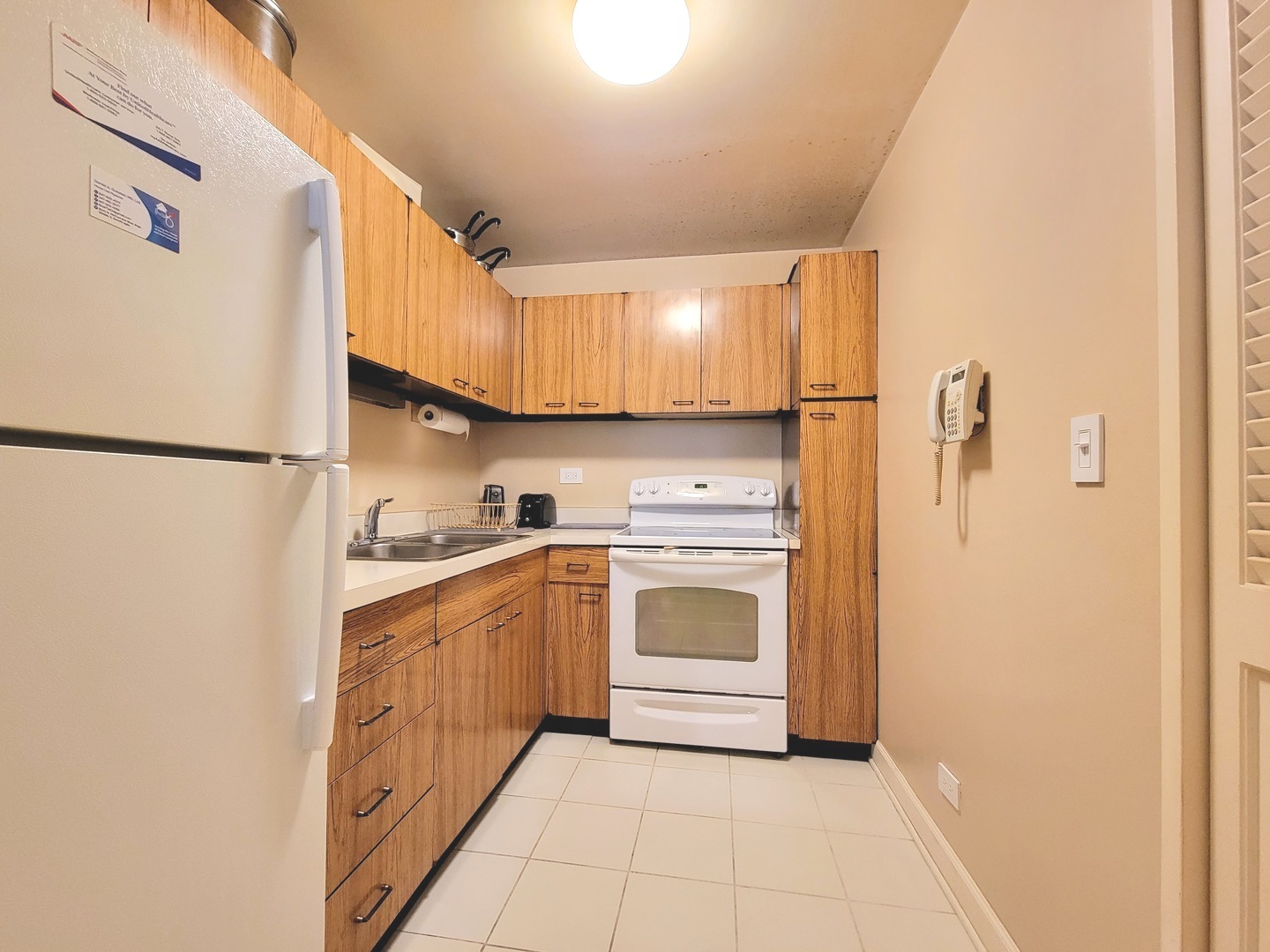 720 West Gordon Terrace, Unit 4M Chicago, IL 60613 - Photo 5 of 7 a kitchen with white cabinets and white appliances