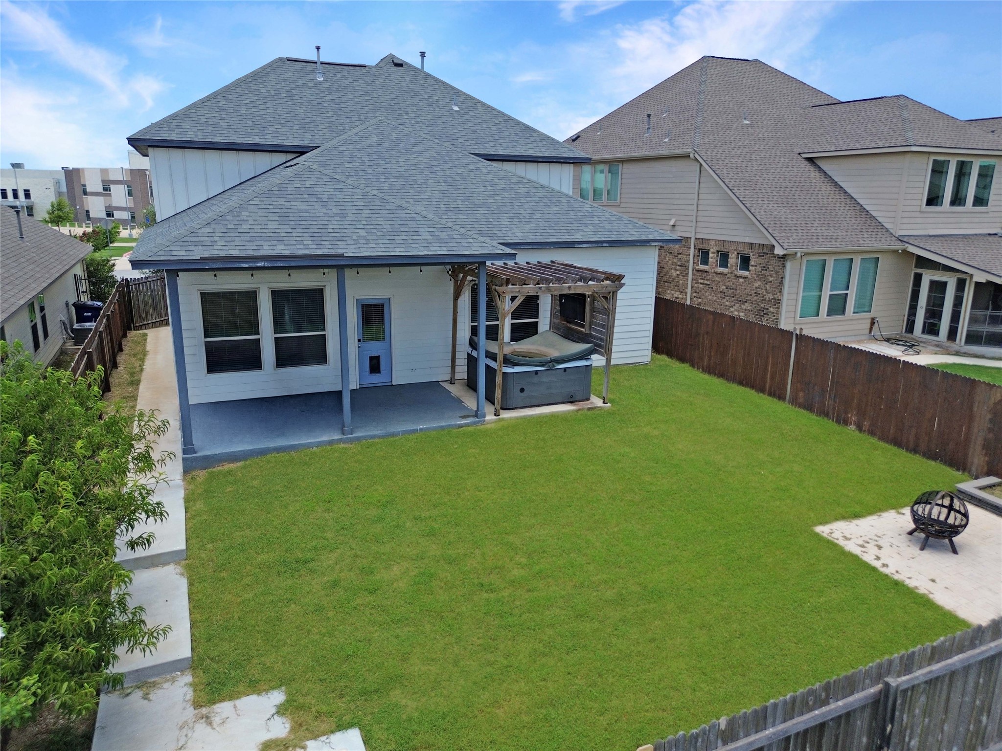 429 Rusk Bluff Avenue Leander, TX 78641 - Photo 20 of 24 A private backyard oasis features a covered patio and a charming pergola-shaded spa, perfect for relaxation.