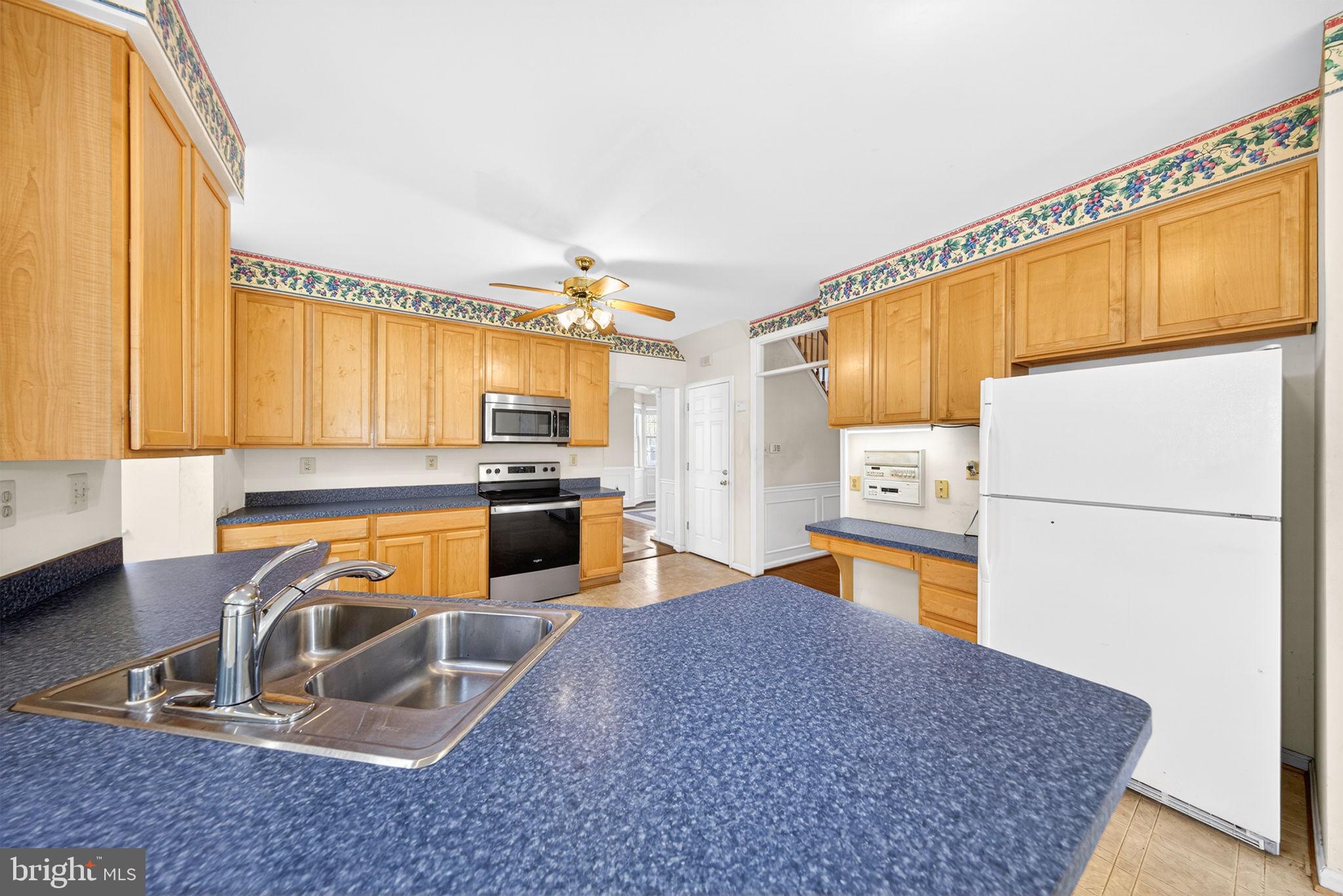 6008 Plata Street Clinton, MD 20735 - Photo 17 of 55 a kitchen with a refrigerator a stove top oven a sink and a window