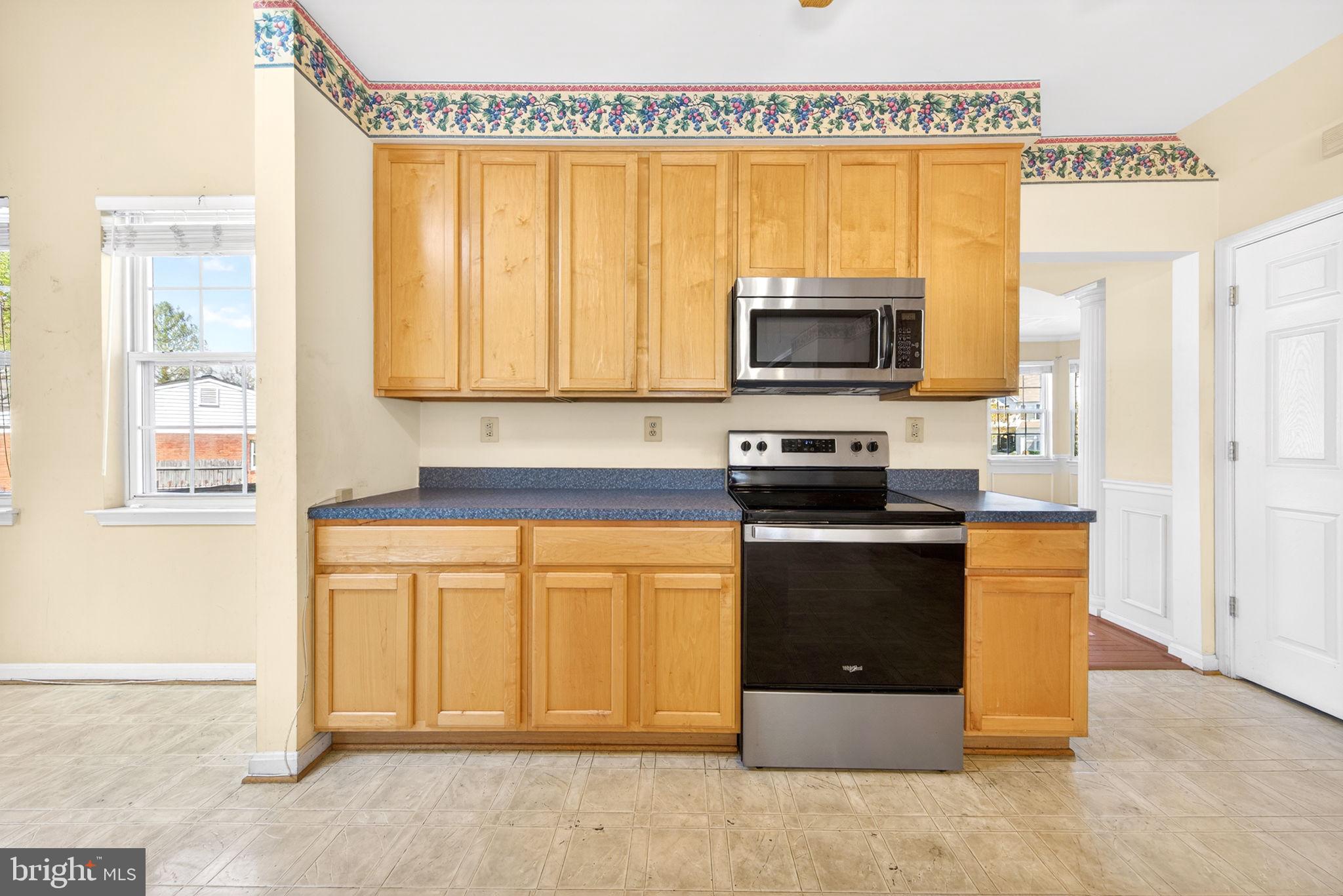 6008 Plata Street Clinton, MD 20735 - Photo 18 of 55 a kitchen with stainless steel appliances granite countertop a stove a microwave and a refrigerator
