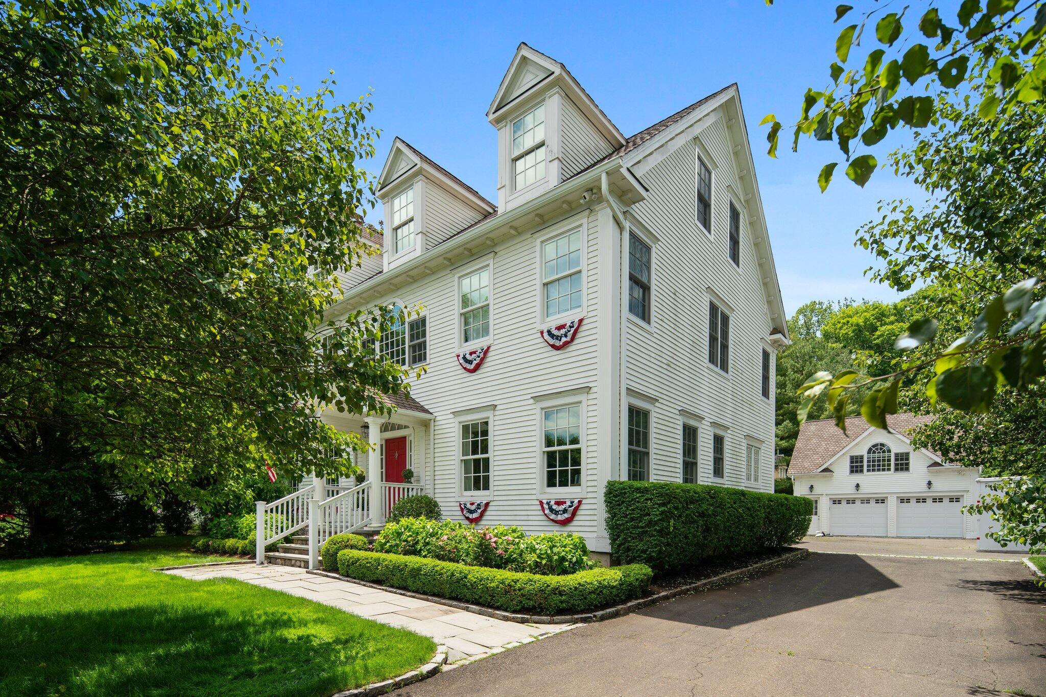 4 Parade Hill Road New Canaan, CT 06840 - Photo 3 of 50 a front view of a house with a garden and plants