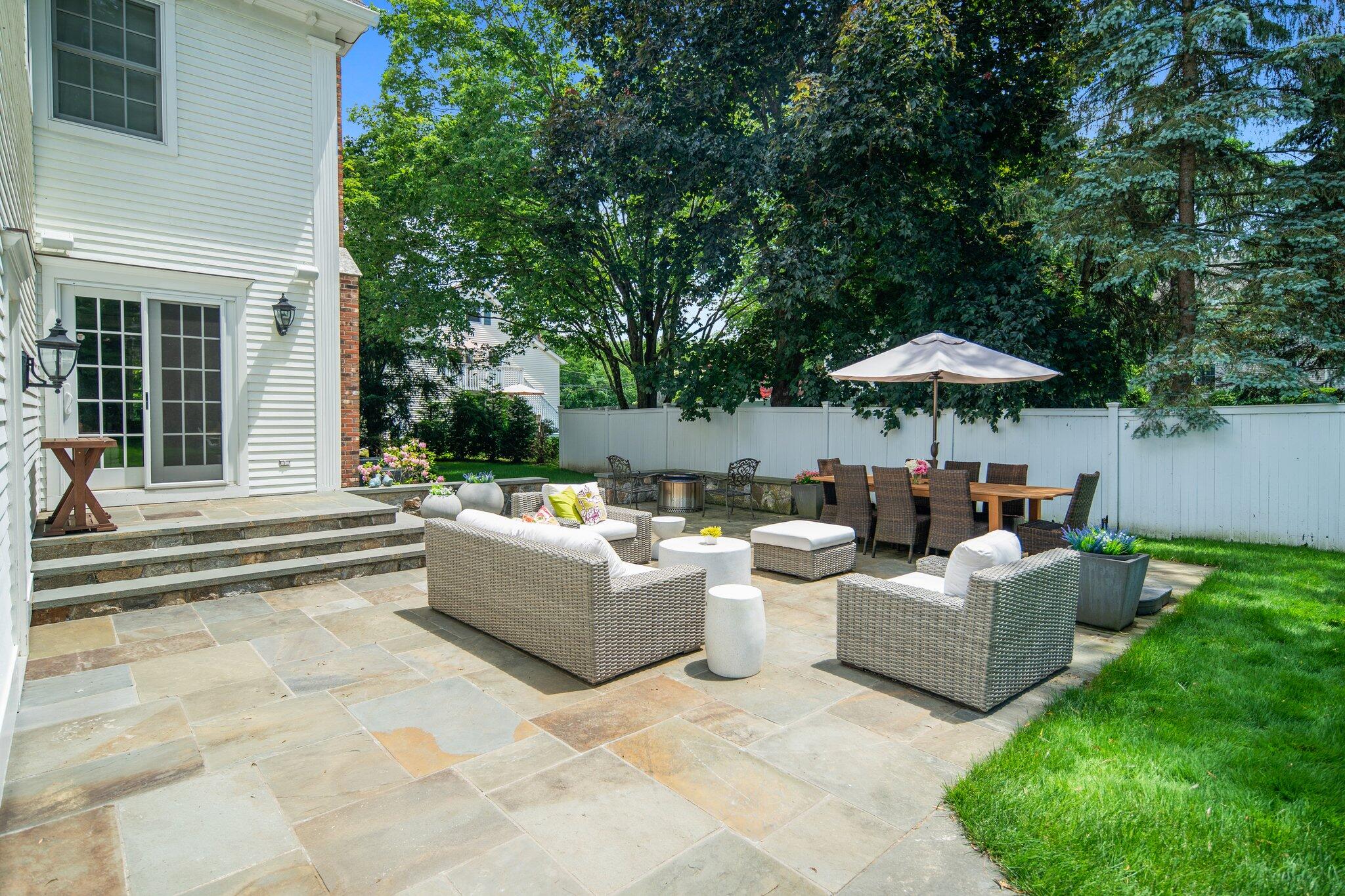4 Parade Hill Road New Canaan, CT 06840 - Photo 40 of 50 a view of a patio with couches and table and chairs under an umbrella