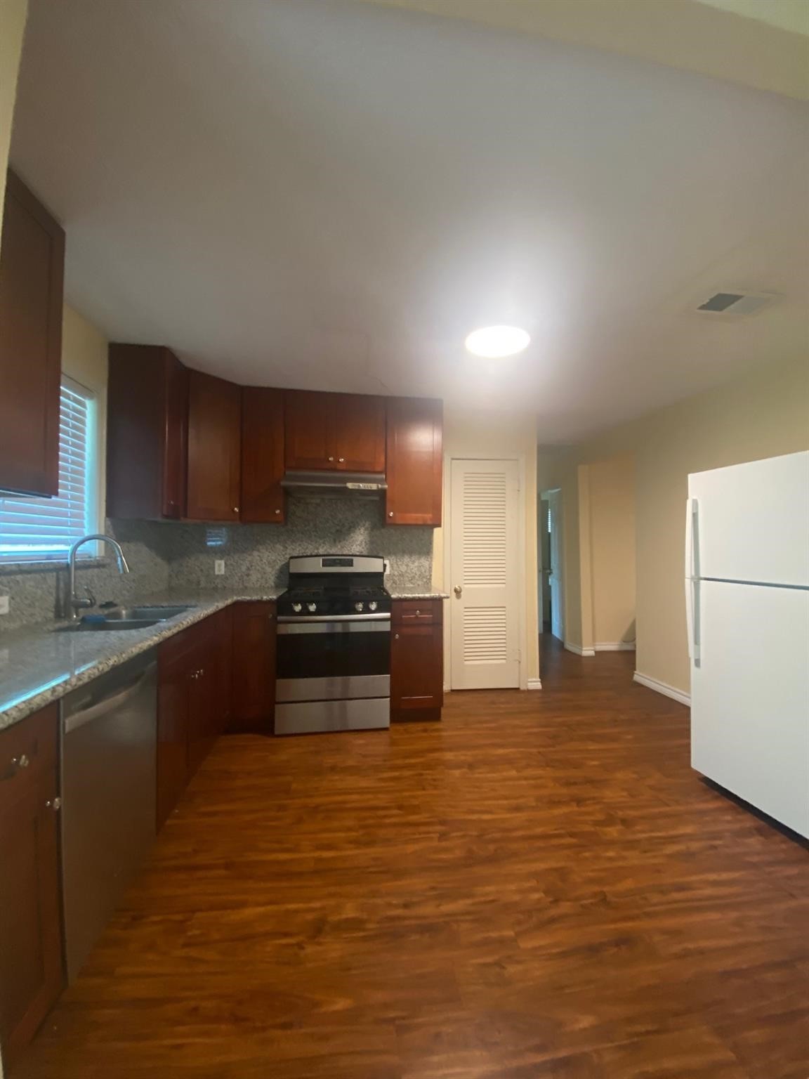 410 Broad Ripple Drive Houston, TX 77336 - Photo 4 of 9 a kitchen with stainless steel appliances granite countertop a stove a sink and a refrigerator