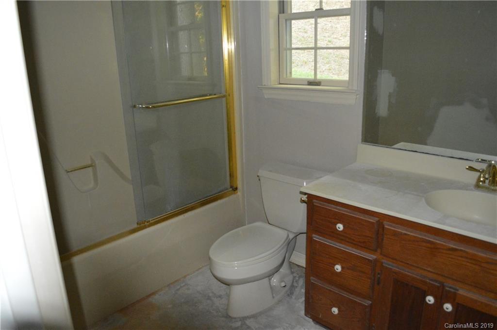 424 Goldfinch Lane Clyde, NC 28721 - Photo 13 of 42 a bathroom with a granite countertop toilet and a sink