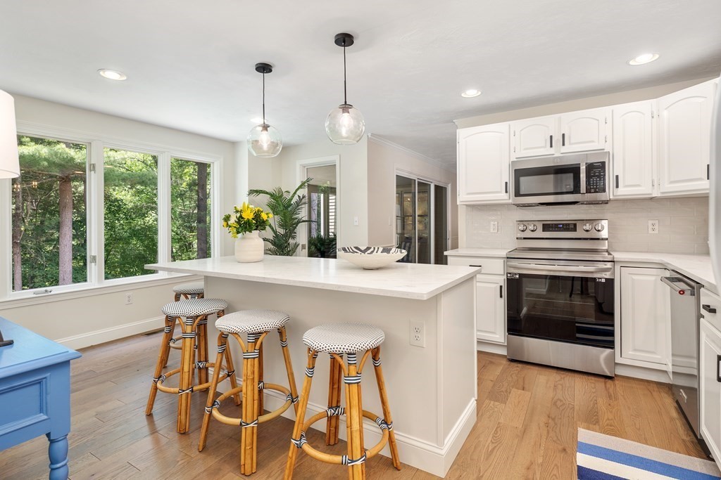 70 Tussock Brook Road, Unit 70 Duxbury, MA 02332 - Photo 1 of 20 a kitchen with stainless steel appliances kitchen island granite countertop a stove a sink a microwave and a refrigerator