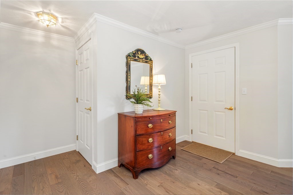 70 Tussock Brook Road, Unit 70 Duxbury, MA 02332 - Photo 13 of 20 an empty room with mirror and a wooden floor