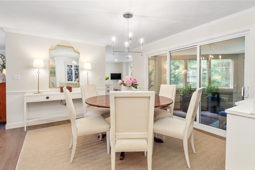 70 Tussock Brook Road, Unit 70 Duxbury, MA 02332 - Photo 6 of 20 a living room with furniture a chandelier and a dining table with a large window