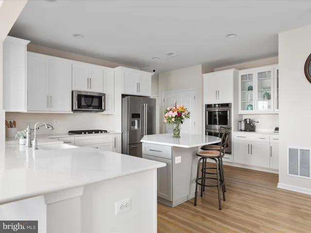 a kitchen with stainless steel appliances granite countertop a kitchen island a stove and a sink