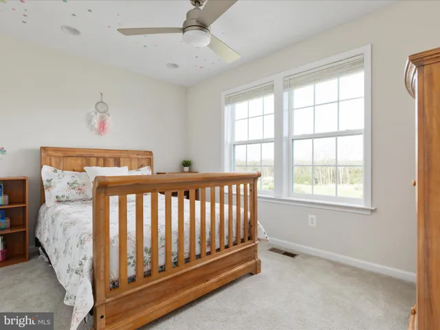a living room with furniture and a large window with ceiling fan