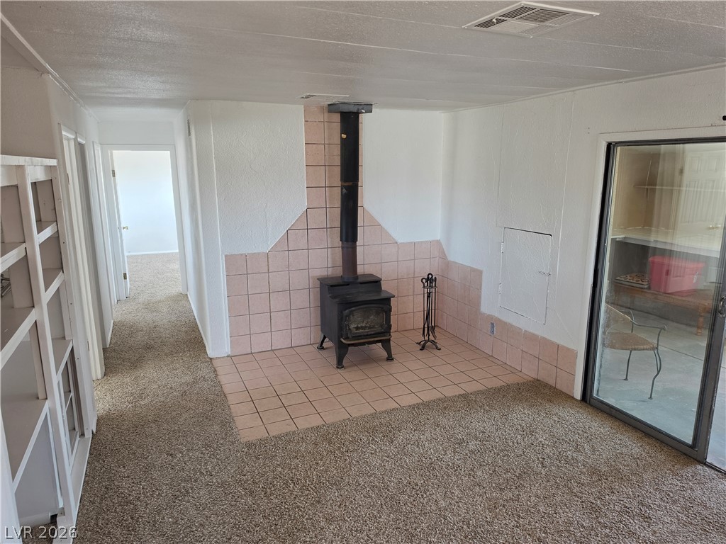 2930 Frehner Ranch Road Pioche, NV 89043 - Photo 33 of 39 A cozy living space boasts a classic wood-burning fireplace and convenient sliding glass door access.
