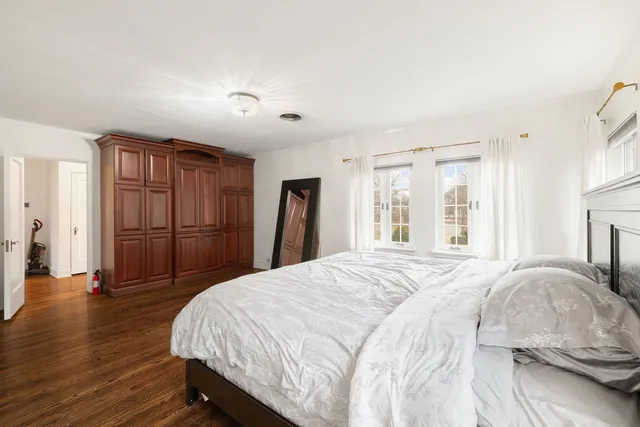 a spacious bedroom with a bed and a large window