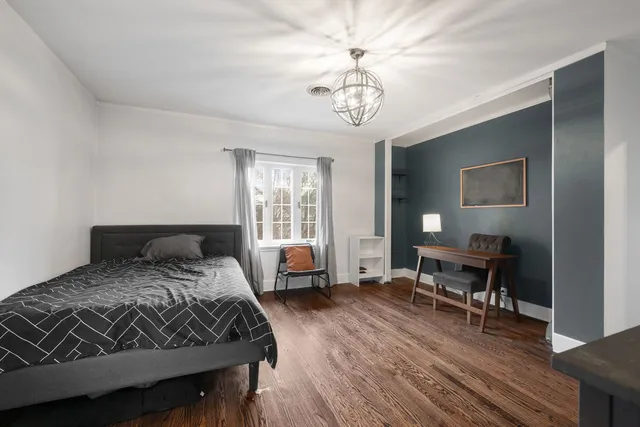 a bedroom with a bed and a table chair