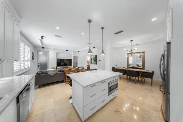 a large kitchen with kitchen island a stove a sink a dining table and chairs