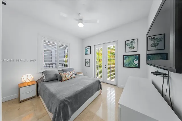 a bedroom with a bed and a flat tv screen on dresser